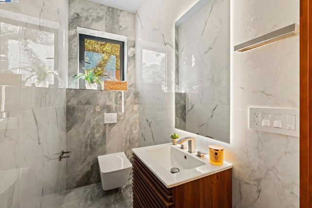 bathroom featuring vanity, tile walls, and toilet