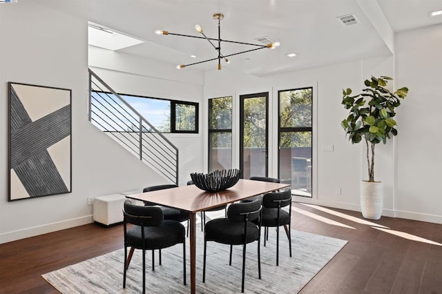 dining area with dark hardwood / wood-style flooring and a notable chandelier