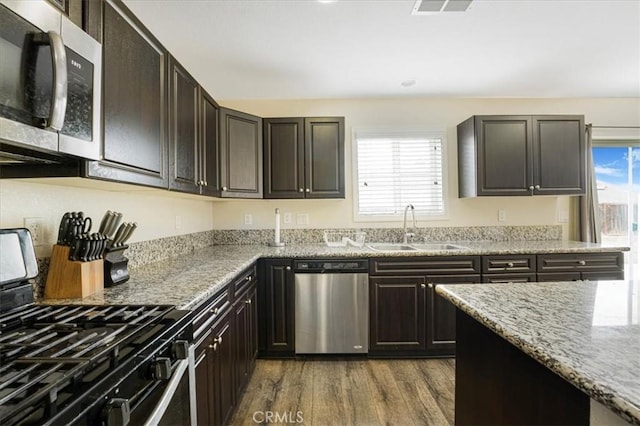 26605 Rose Bud Ln, Moreno Valley, CA 92555 - kitchen featuring visible vents, a sink, stainless steel appliances, dark wood-type flooring, and light stone counters