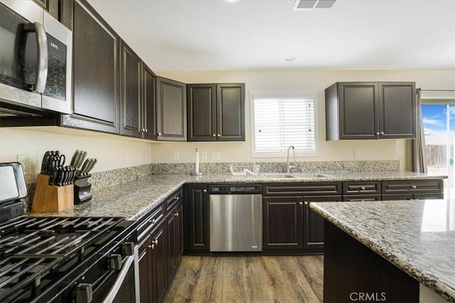 26605 Rose Bud Ln, Moreno Valley, CA 92555 - kitchen featuring appliances with stainless steel finishes, dark wood finished floors, and light stone counters