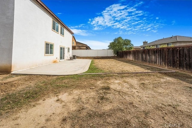 view of yard with a patio, central AC unit, and a fenced backyard