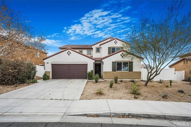 mediterranean / spanish-style house with concrete driveway, fence, a garage, and stucco siding