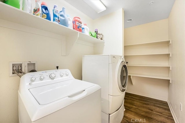 clothes washing area with baseboards, dark wood-type flooring, laundry area, and washer and clothes dryer