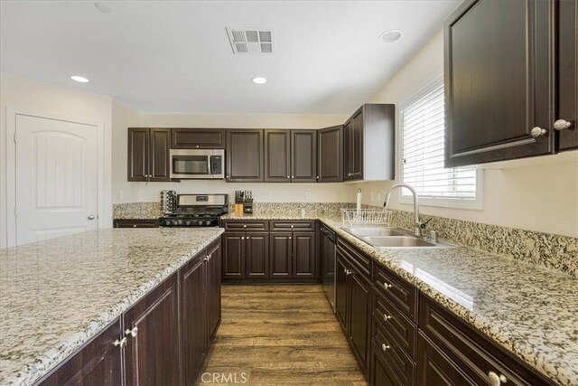 26605 Rose Bud Ln, Moreno Valley, CA 92555 - kitchen with dark wood-type flooring, dark brown cabinets, visible vents, a sink, and stainless steel appliances