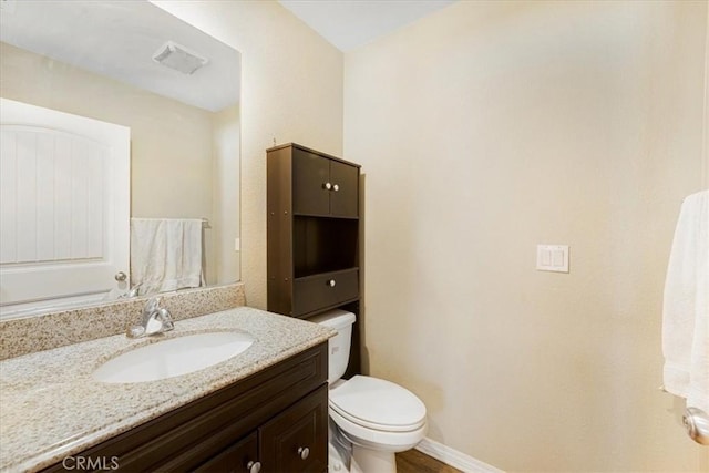 bathroom with visible vents, toilet, vanity, and baseboards