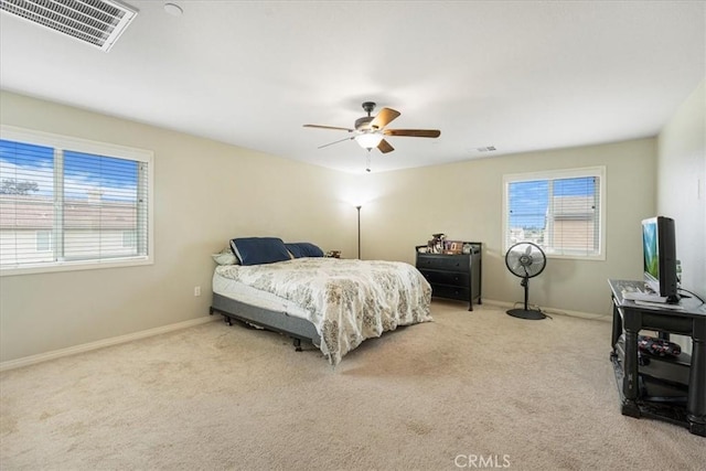 carpeted bedroom featuring baseboards, visible vents, and ceiling fan