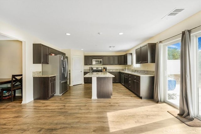 26605 Rose Bud Ln, Moreno Valley, CA 92555 - kitchen with a kitchen island, visible vents, stainless steel appliances, light wood finished floors, and a sink