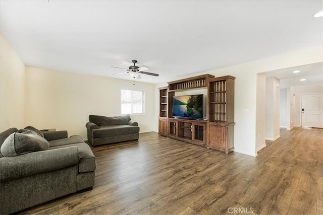 living area with ceiling fan, baseboards, and wood finished floors