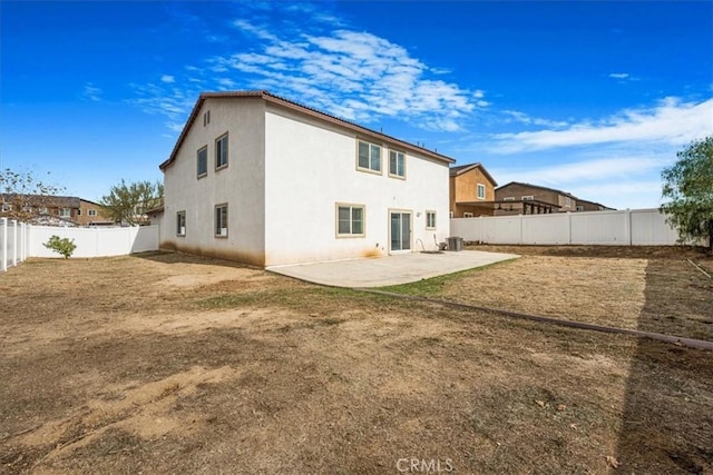 rear view of house featuring stucco siding, cooling unit, a fenced backyard, and a patio area