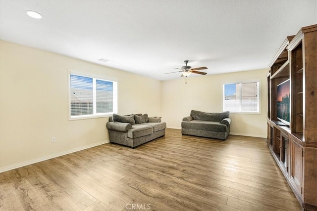 living room featuring a wealth of natural light, baseboards, and wood finished floors