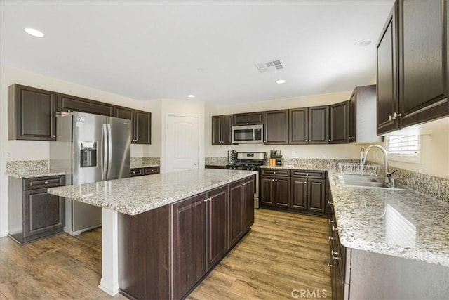 26605 Rose Bud Ln, Moreno Valley, CA 92555 - kitchen featuring visible vents, a center island, a sink, stainless steel appliances, and light wood-style flooring