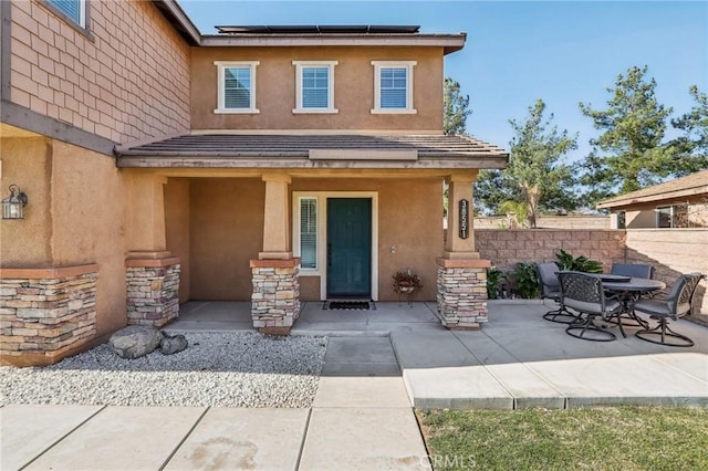 entrance to property with a patio area and solar panels