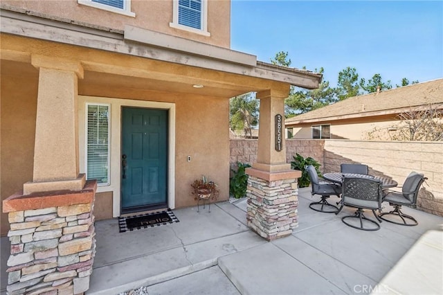 view of exterior entry with a patio area