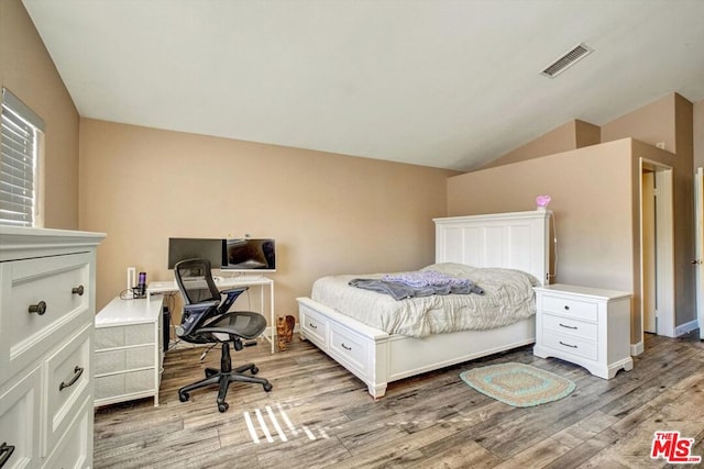 bedroom featuring lofted ceiling and light wood-type flooring