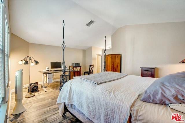 bedroom featuring vaulted ceiling and light wood-type flooring