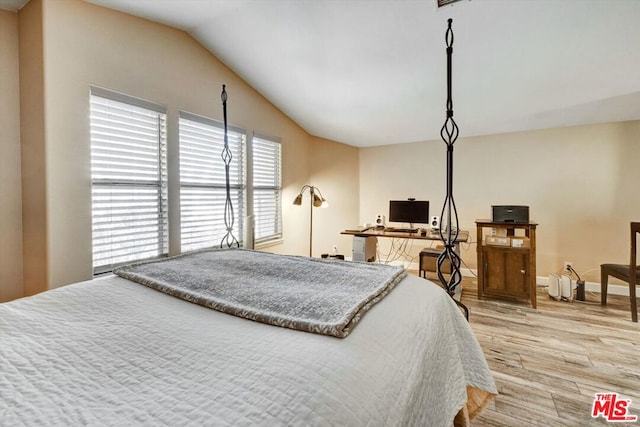 bedroom featuring lofted ceiling and light wood-type flooring