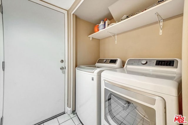 laundry area with light tile patterned flooring and separate washer and dryer