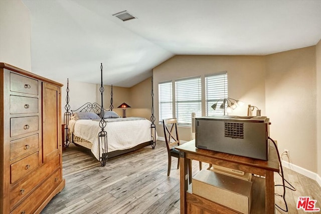 bedroom featuring lofted ceiling and light hardwood / wood-style floors