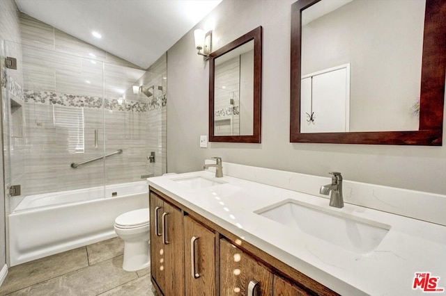 full bathroom with vaulted ceiling, tiled shower / bath, vanity, toilet, and tile patterned floors