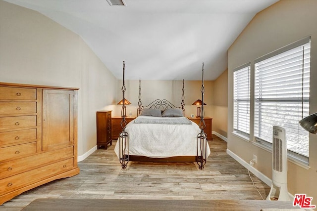 bedroom featuring lofted ceiling and light hardwood / wood-style floors