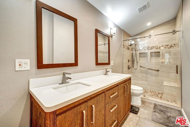 bathroom featuring vaulted ceiling, tile patterned flooring, vanity, toilet, and a shower with door