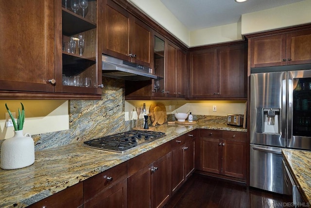 kitchen with dark hardwood / wood-style flooring, decorative backsplash, light stone counters, stainless steel appliances, and dark brown cabinets