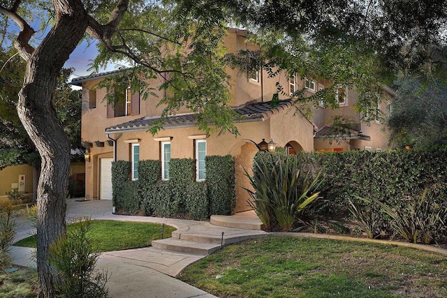 view of front of home featuring a garage and a lawn