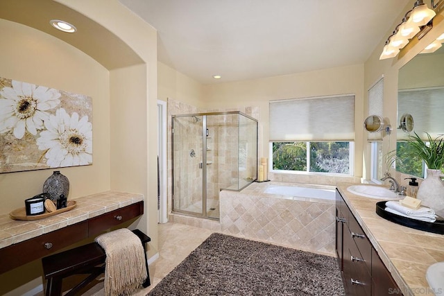 bathroom with vanity and shower with separate bathtub