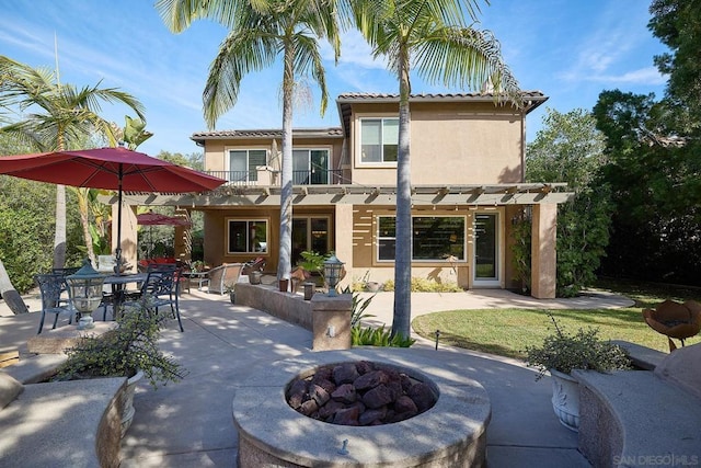 rear view of house featuring a pergola, a fire pit, a patio, and a balcony