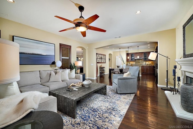 living room with dark hardwood / wood-style floors and ceiling fan