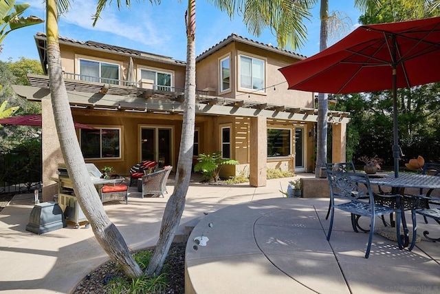 rear view of property with a balcony, a patio area, and a pergola