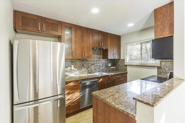 kitchen with dark stone countertops, backsplash, and appliances with stainless steel finishes