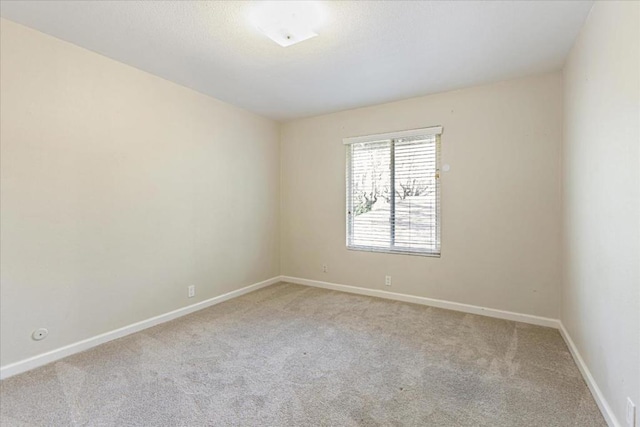 unfurnished room featuring light colored carpet