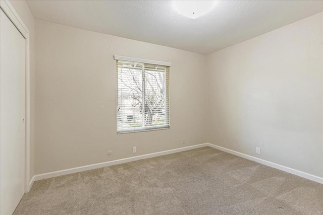 spare room featuring light colored carpet