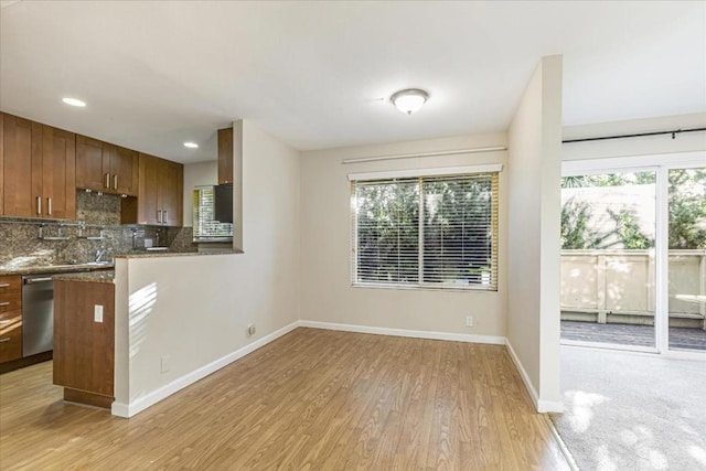 kitchen featuring dishwasher, a wealth of natural light, backsplash, and light wood-type flooring