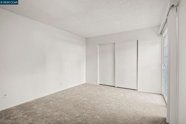 unfurnished bedroom featuring carpet, a textured ceiling, and a closet