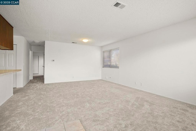 carpeted empty room featuring a textured ceiling