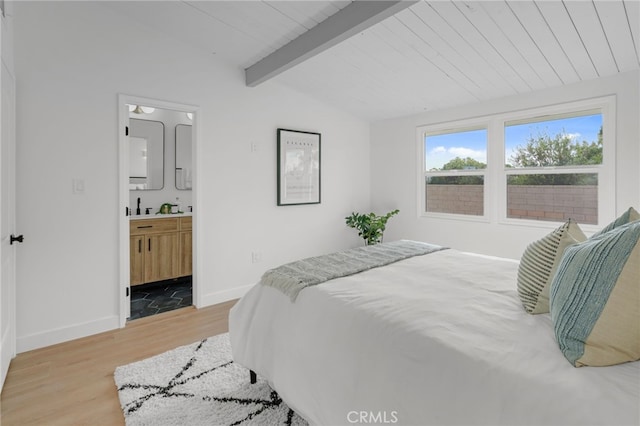 bedroom with wooden ceiling, connected bathroom, lofted ceiling with beams, and light wood-type flooring