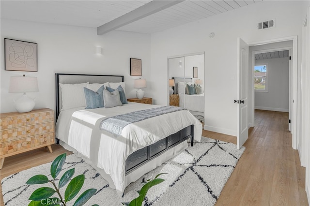 bedroom with light hardwood / wood-style flooring and vaulted ceiling with beams