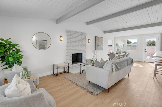 living room with a fireplace, lofted ceiling with beams, and light hardwood / wood-style flooring