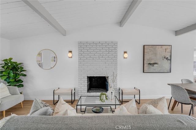 living room with hardwood / wood-style flooring, lofted ceiling with beams, and a brick fireplace