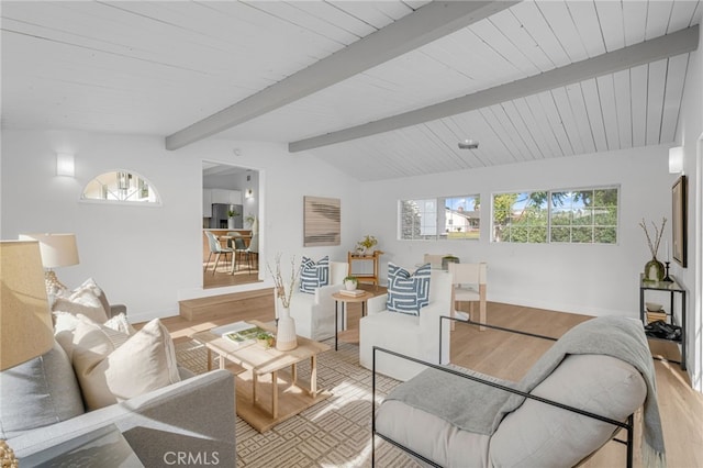 living room featuring vaulted ceiling with beams and light hardwood / wood-style flooring