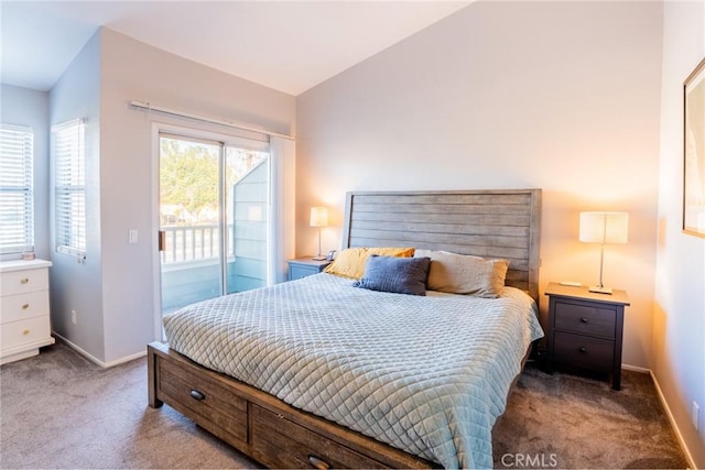 bedroom with vaulted ceiling, access to exterior, and carpet floors