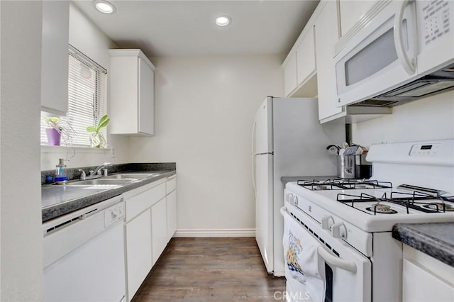 kitchen with white appliances, dark hardwood / wood-style flooring, sink, and white cabinets