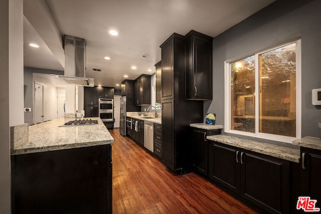 kitchen featuring sink, light stone counters, dark hardwood / wood-style floors, island exhaust hood, and stainless steel appliances