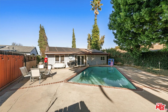 view of swimming pool with grilling area and a patio