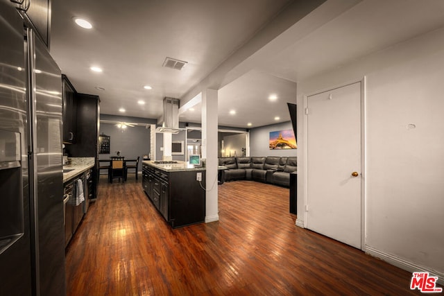 kitchen featuring appliances with stainless steel finishes, dark wood-type flooring, island range hood, and light stone counters