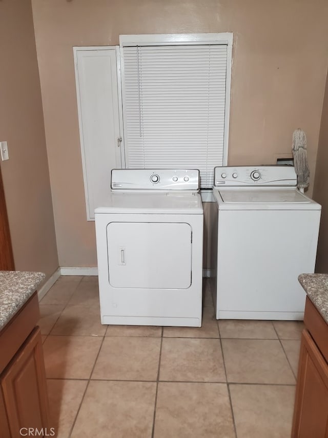 laundry area featuring washing machine and clothes dryer and light tile patterned floors