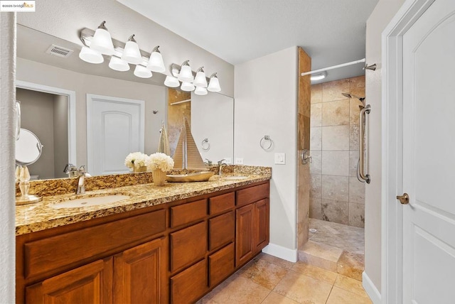 bathroom featuring tiled shower and vanity