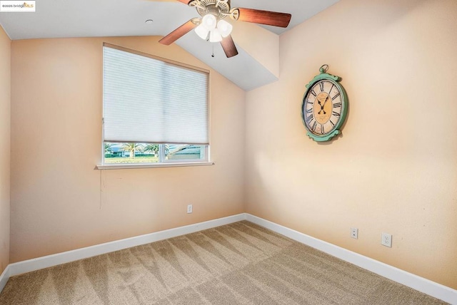 carpeted spare room featuring ceiling fan and vaulted ceiling